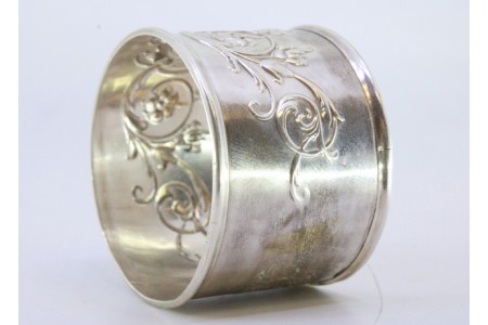 Argola de guardanapo em prata com motivos florais relevados envolvendo cartela para monograma.